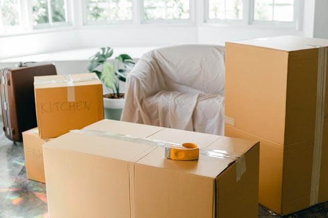 stacked boxes and covered furniture in preparation for moving.